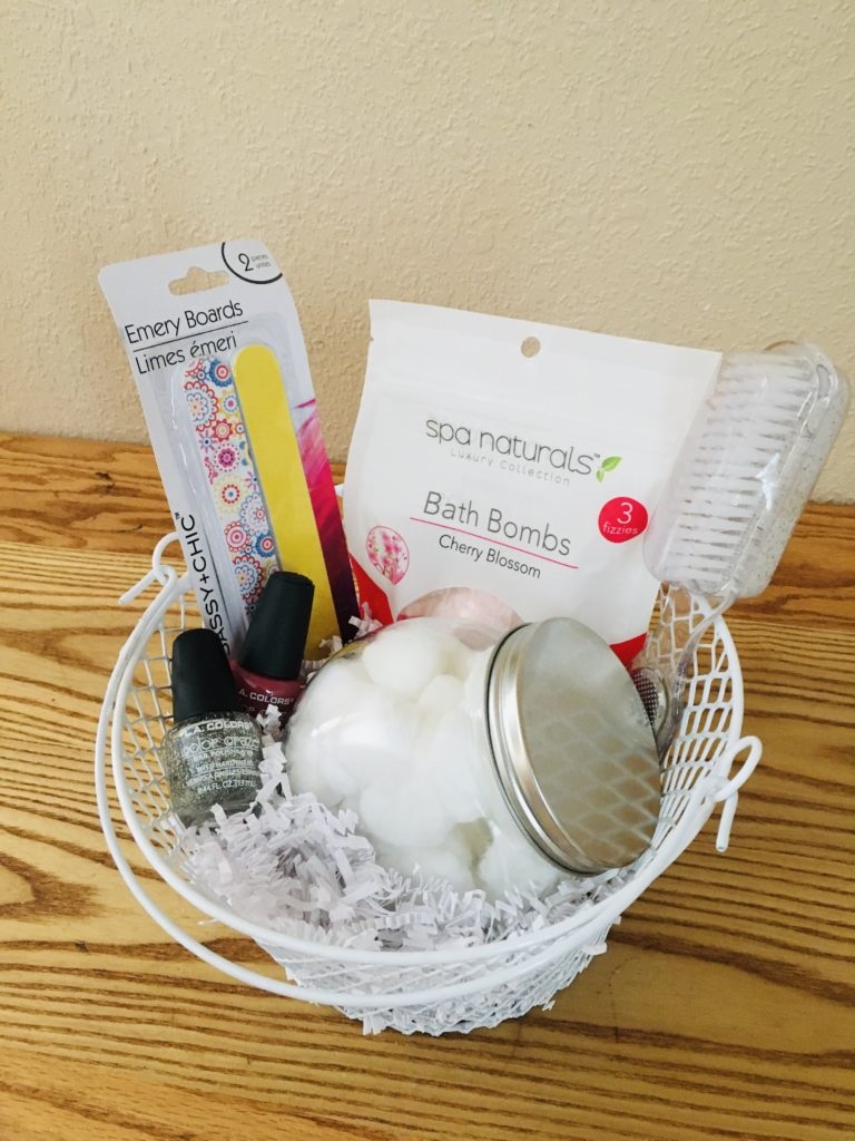 Spa gift basket with nail polish, bath bombs, jar full of cotton balls, emery boards and foot scrub brush